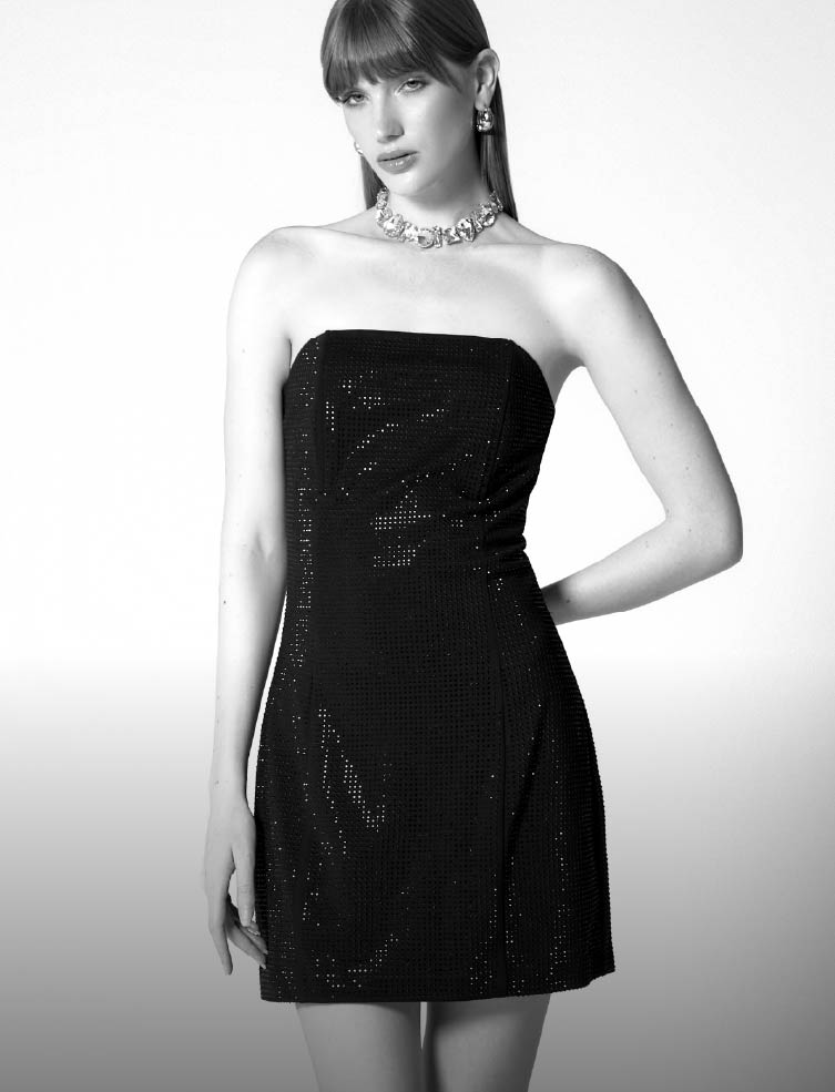 Foto de mujer usando vestido largo de color blanco sobre fondo negro